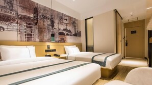 Ein Hotelzimmer mit zwei Betten, einem großen Wandbild, einem Nachttisch und einem Sessel.
