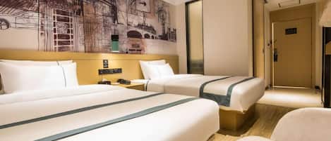 A hotel room with two beds, a large wall mural, a bedside table, and a chair.