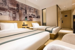 Ein Hotelzimmer mit zwei Betten, einem großen Wandbild, einem Nachttisch und einem Sessel.