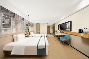 Ein Hotelzimmer mit zwei Betten, einem Fernseher, einem Schreibtisch mit Stuhl und einer großen Wandmalerei.