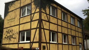 Um edifício tradicional em estilo de enxaimel com uma placa indicando "Ferienhaus 'Am Waldesrand'".