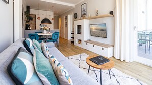 Un soggiorno moderno con un divano, un tavolino da caffè e una TV a parete.