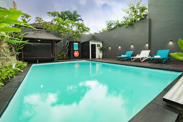 Una piscina al aire libre, tumbonas