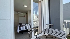 A balcony with a wooden bench and table, a bed with striped bedding, and a view of the outside. - T-0721, Havanna, villa in Mimosa II with 3 bedrooms (Els Poblets)