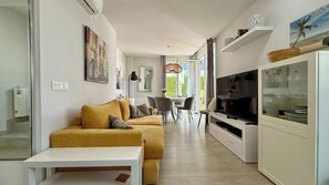 A modern living room with a sofa, dining area, and TV. - T-0721, Havanna, villa in Mimosa II with 3 bedrooms (Els Poblets)