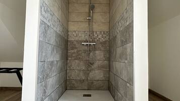 Een douche, een haardroger, handdoeken, toiletpapier