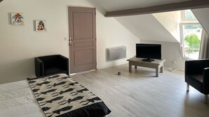 A room with a bed, a TV, a desk, and a window. - Chambre Bonheur (Romeries)