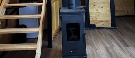 Una cocina moderna con estufa integrada, repisas de madera y una escalera.