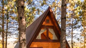 Eine Holzhütte mit geneigtem Dach und einer Eingangstür.