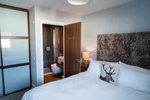 Relax in a spacious room with a large bed, a wardrobe, and a bathroom featuring a toilet and sink.