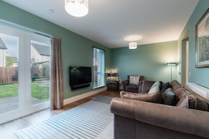 Relax in comfort with a large flat-screen TV, plush sofa, and cozy reading nook.