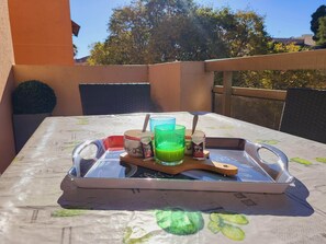 A table with a tray, a mug, a glass of green drink, and a container of yogurt.
