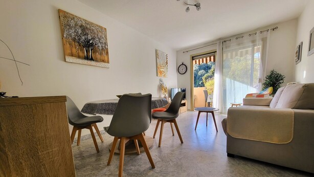 Un soggiorno moderno con zona pranzo, un divano e una televisione.