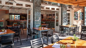 A restaurant interior with wooden beams, tiled walls, and multiple seating areas.