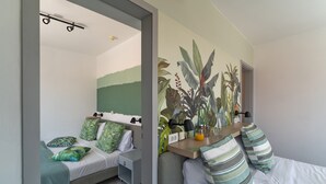 A bedroom with a bed, bedside table, and a wall mural.