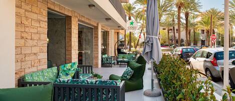 An outdoor seating area with green furniture and a stop sign in the background.