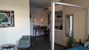 Eine moderne Wohnung mit Essbereich, Küchenzeile und einem Schlafzimmer mit Bett und Nachttisch.