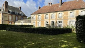 A large, historic building with multiple windows and a well-maintained lawn. - 18th century castle (Saint-Luperce)
