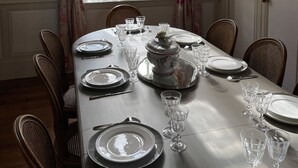 A dining table set for six with plates, glasses, and a centerpiece. - 18th century castle (Saint-Luperce)