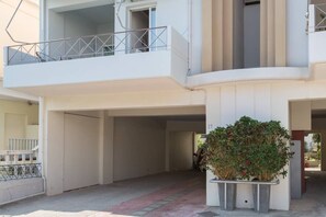 Een gebouw met meerdere verdiepingen, een balkon, een bloempot en een heldere lucht.