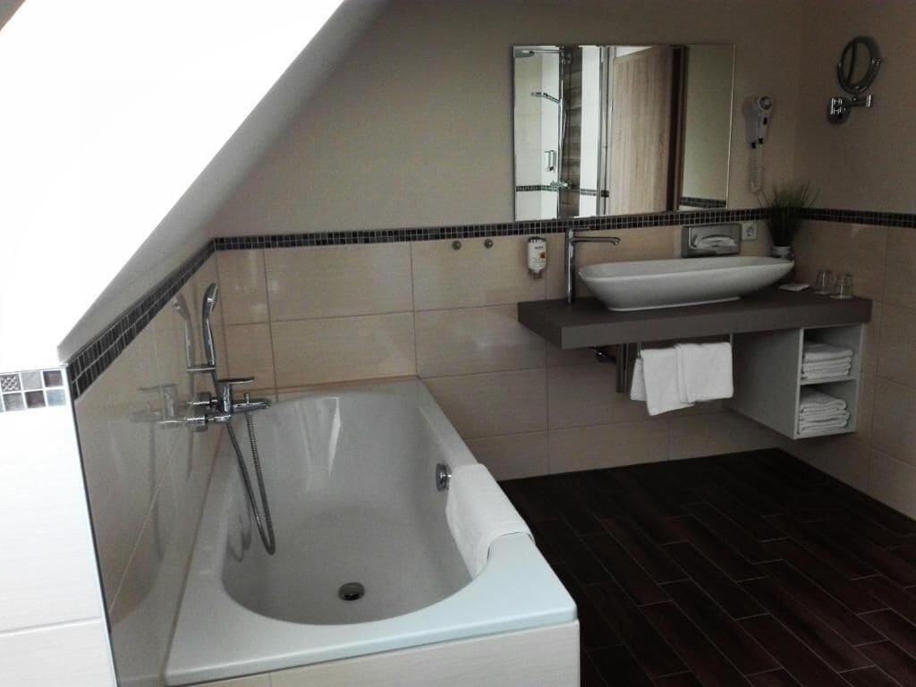 A modern bathroom with a freestanding bathtub, a vanity with a mirror, and a towel rack.