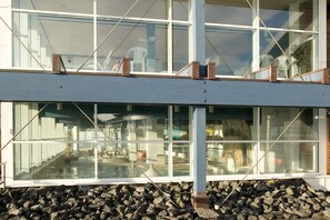 A modern building with large windows overlooking a swimming pool area. - Apartment on Strandstrasse in Büsum / 2 bathrooms / 2 bedrooms (Büsum)