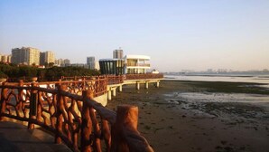 A waterfront promenade with a wooden bridge, modern buildings, and a view of the sea. - City Comfort Inn (Zhanjiang)