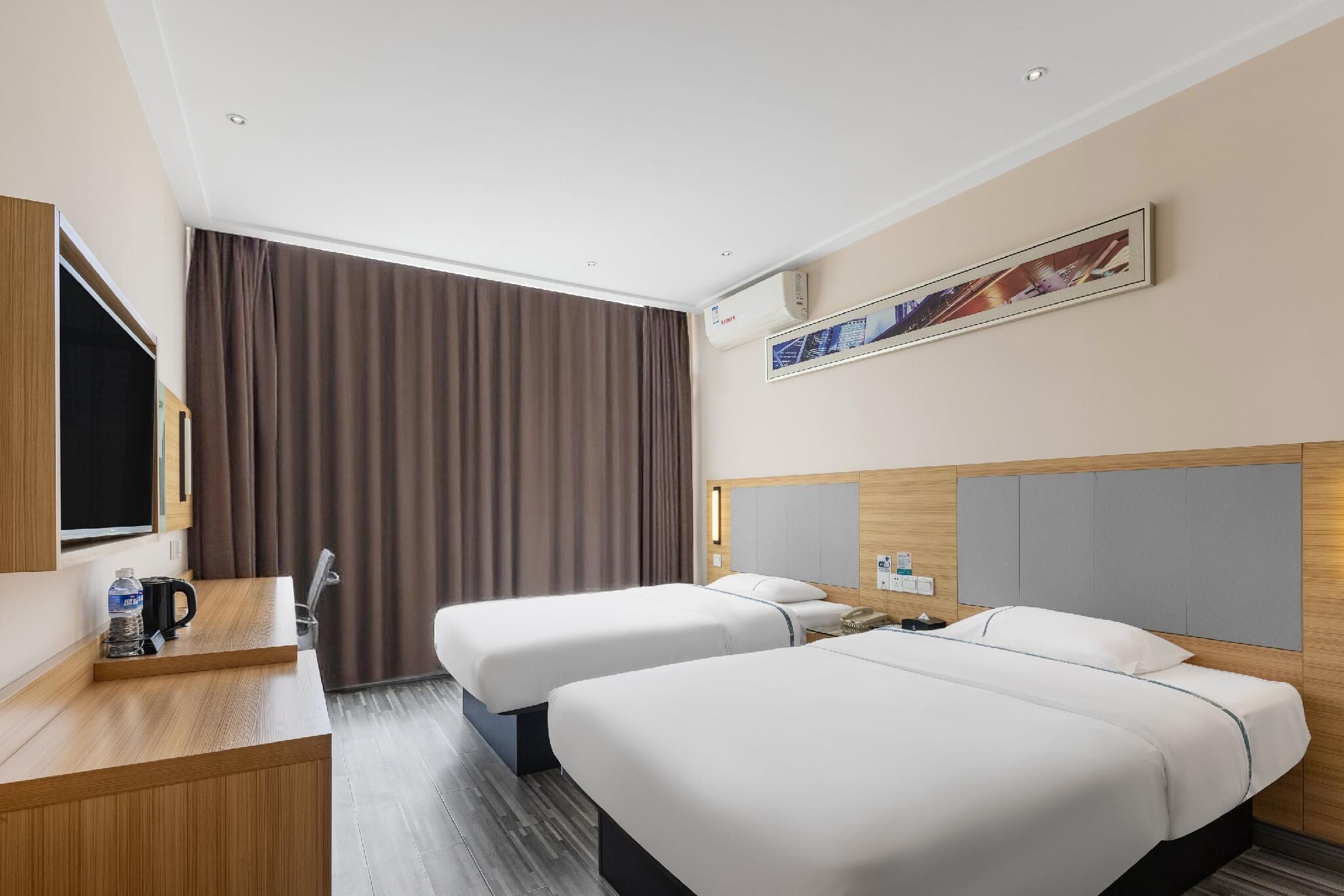 A hotel room with two beds, a desk with a coffee maker, a TV, and a large window with curtains.