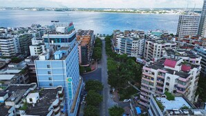 A high-rise hotel with multiple floors, a central courtyard, and a view of the sea. - City Comfort Inn (Zhanjiang)