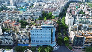 A multi-story hotel with a central courtyard, surrounded by other buildings. - City Comfort Inn (Zhanjiang)