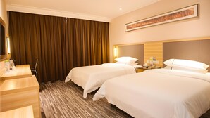 A hotel room with two beds, a wooden desk, a mirror, and a large window with curtains. - City Comfort Inn (Zhanjiang)