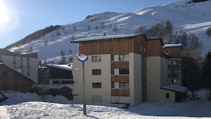 A snow-covered building with a sign indicating it is a ski resort.