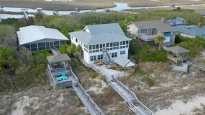 A coastal property with multiple buildings, including a large house with a balcony and a smaller structure with a deck. - Ocean & Creekfront: Selah mid Island, Porches, Decks, Dock (Pawleys Island)