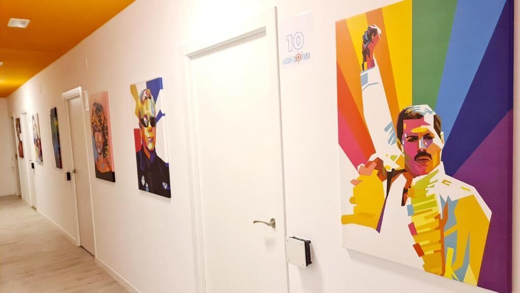 A hallway with artwork on the walls, a door labeled '10', and a brightly lit ceiling.