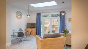 Un salon moderne avec un canapé, une table à manger et un téléviseur.