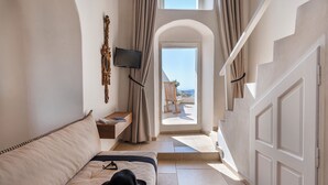 Habitación de hotel con cama, televisión, ventana con cortinas y vista a la playa.
