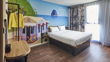 Une chambre d’hôtel avec un lit, une armoire, un miroir et une fresque murale.