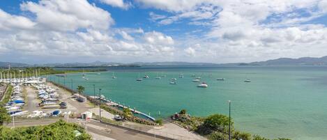 A marina with boats, a road, and a clear sky.