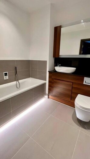 Chuveiro, banheira de imersão, secador de cabelo, toalhas de banho