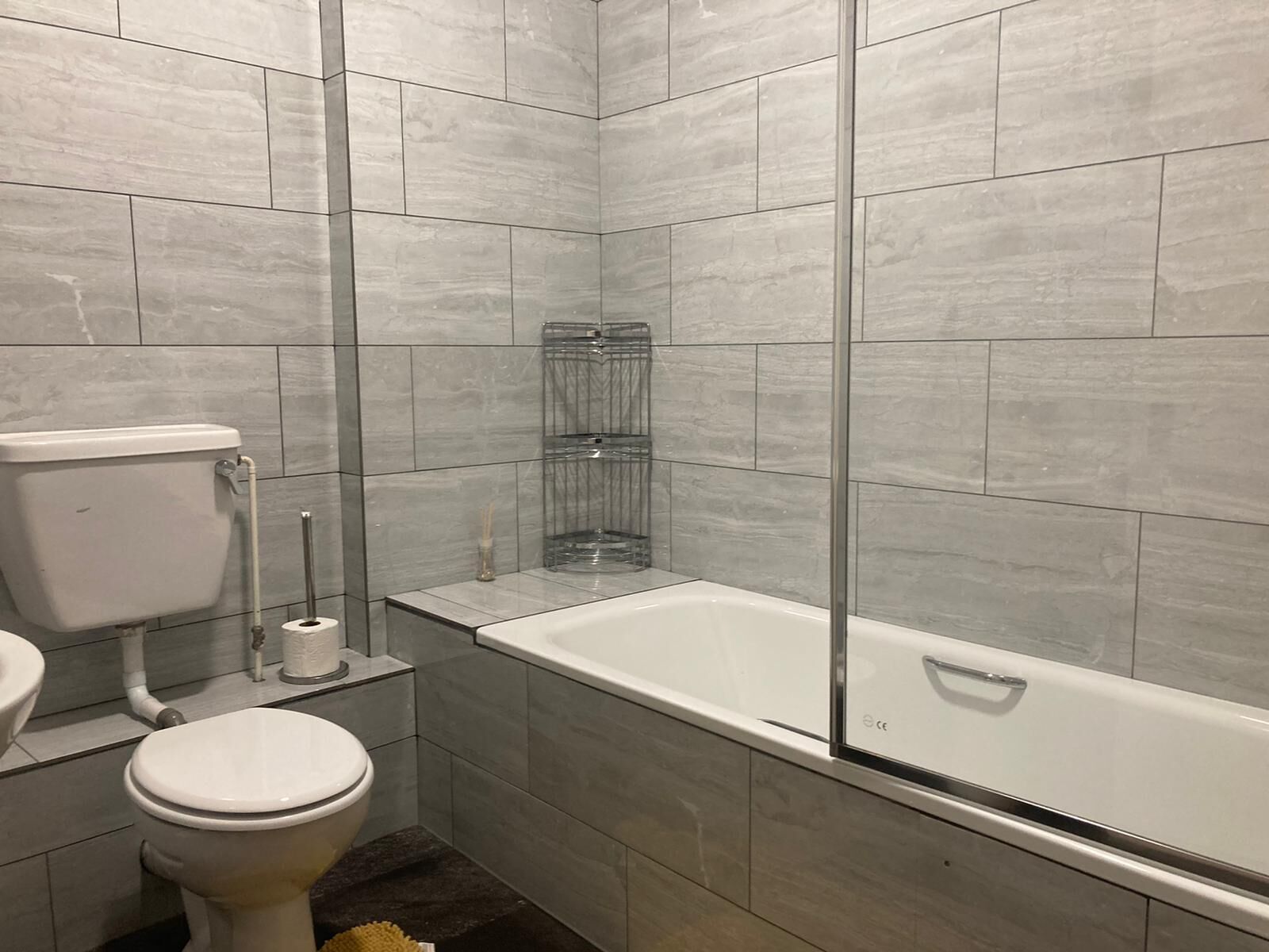 A modern bathroom with a toilet, sink, and a walk-in shower with a glass enclosure.