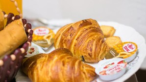 Um prato com croissants e um pote de iogurte com mel.