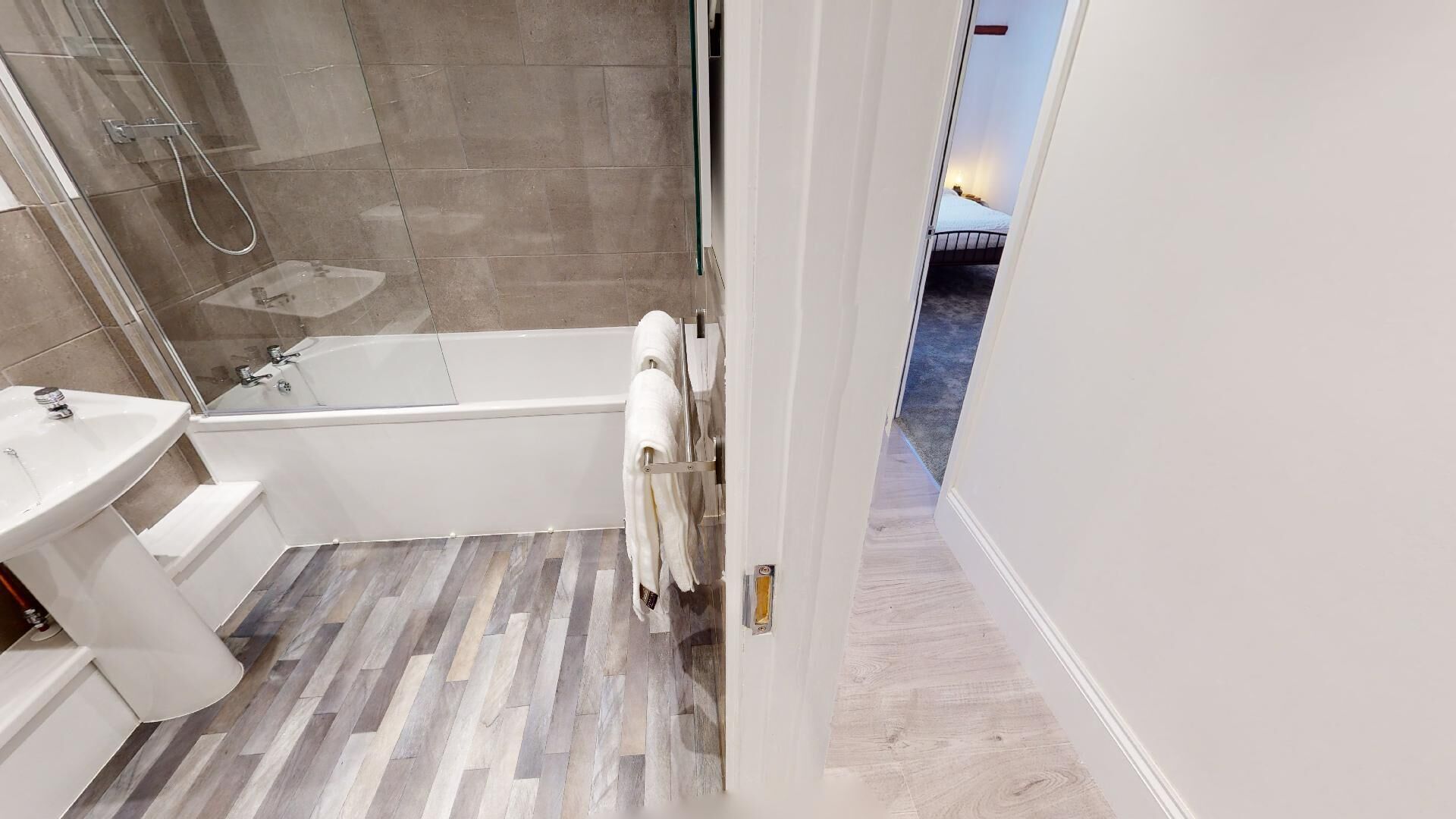 A modern bathroom with a shower, a bathtub, and a sink.