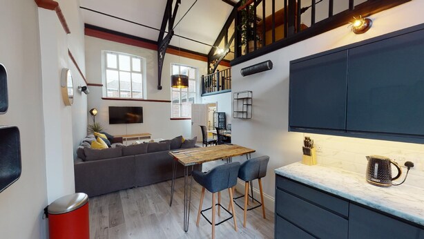 A compact living space with a sofa, dining table, and kitchen area.