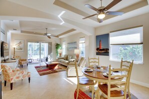 A spacious living room with a dining area, ceiling fans, and large windows. - Calming Estero Home w/ Community Pool & More! (Estero)
