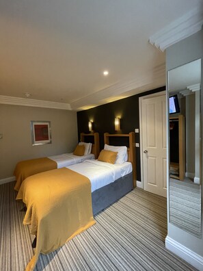 A hotel room with two beds, a television, and a door leading to another room. - Shandon Hotel (Richmond)