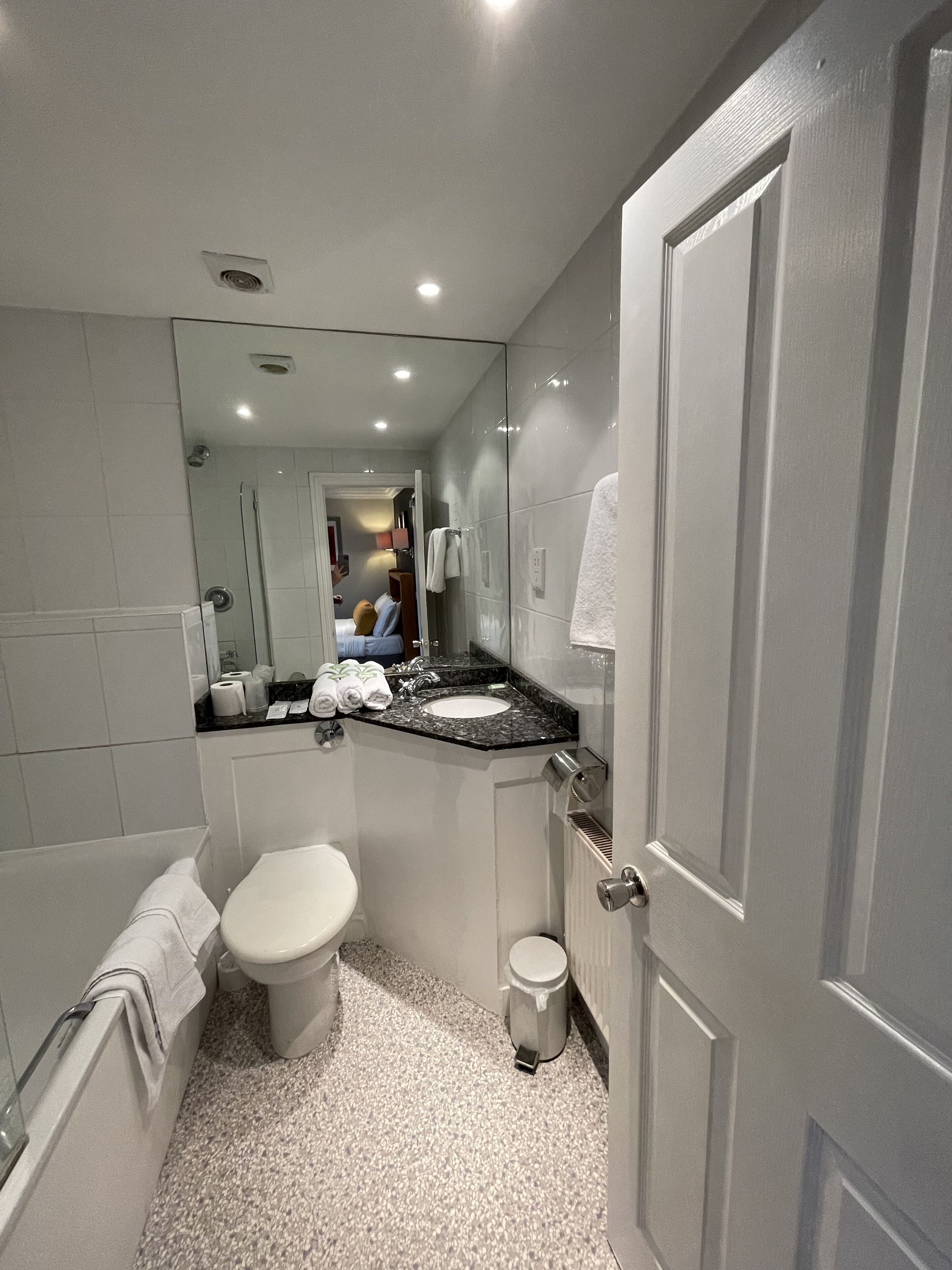 A modern bathroom with a toilet, sink, and shower.