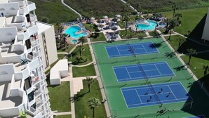 Ett semesterhotell med utsikt över stranden, tennisbanor och en swimmingpool.