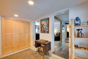 A hallway with a wooden wardrobe, a sewing machine, and a painting on the wall.