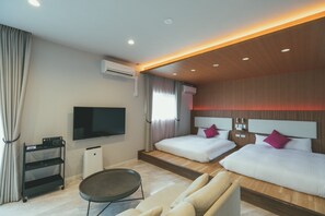 Una habitación de hotel con dos camas, televisión, escritorio y una silla.