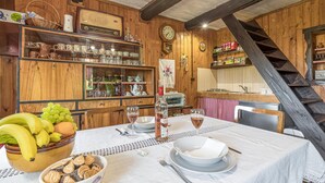 A wooden interior with a dining table set for two, a radio, and a clock on the wall. - Chalet Birchwood With Hot Tub and Sauna (Breznički Hum)